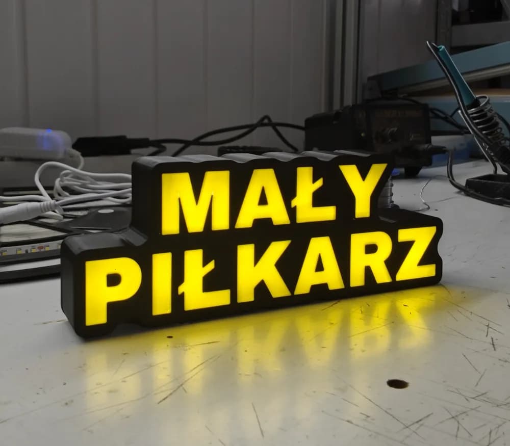 Podświetlana lampka z napisem MAŁY PIŁKARZ na stole - zdjęcie z pierwszego wydruku w pracowni